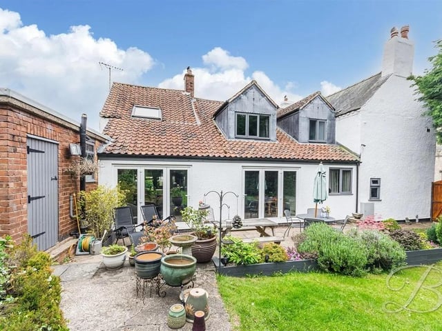 At the rear of the property, a spacious patio opens onto a well-kept lawn.
