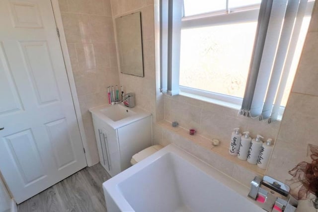 The well-presented family bathroom from a different angle. The floor is tiled, and there is a chrome, heated towel-rail