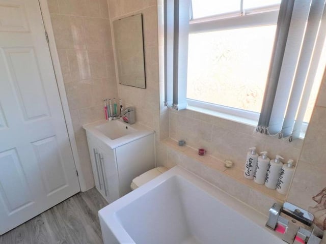The well-presented family bathroom from a different angle. The floor is tiled, and there is a chrome, heated towel-rail
