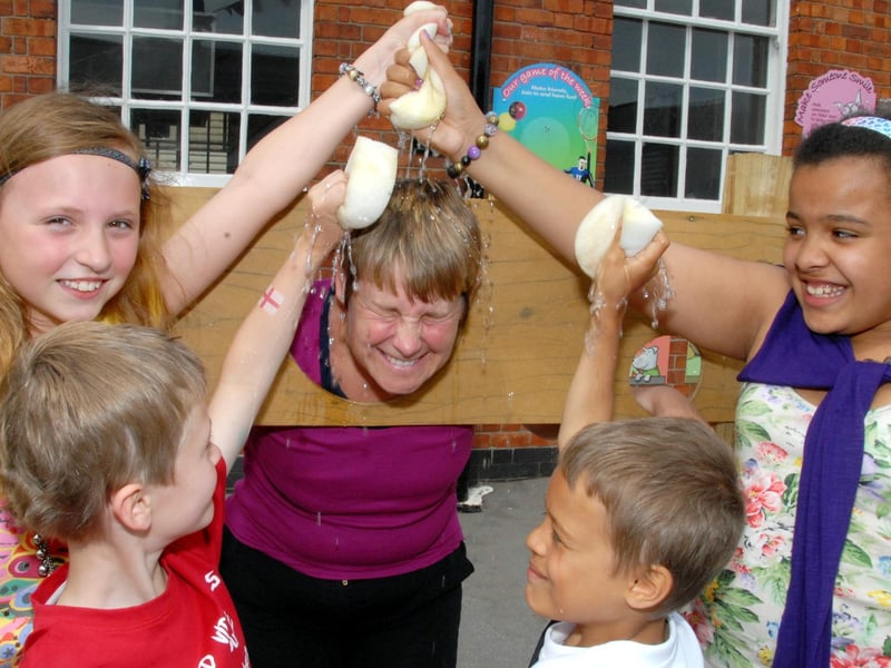 Pictured is Year 3 and 4 Teacher Jill Robinson in the stocks being sponged by youngsters, from the left; Rebecca Quinton, 10, Archie Adams, 8, Enryece McKenzie, 7 and Tia Francis, 10. Sutton's Croft School's annual Summer Fair.