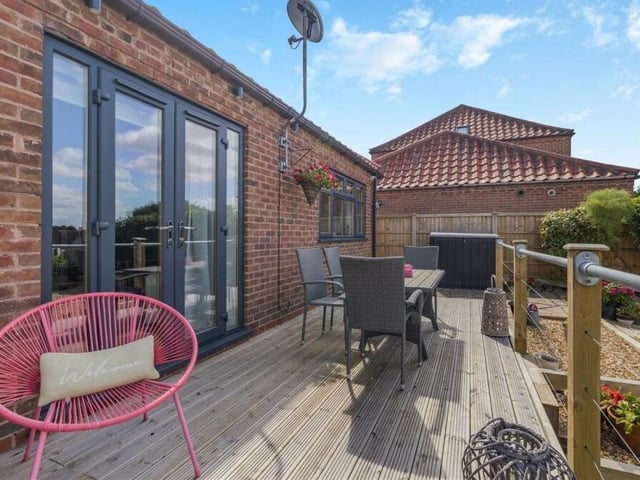 A shot of the spacious, decked balcony-patio from a different angle. Imagining relaxing out here on a warm summer's day.