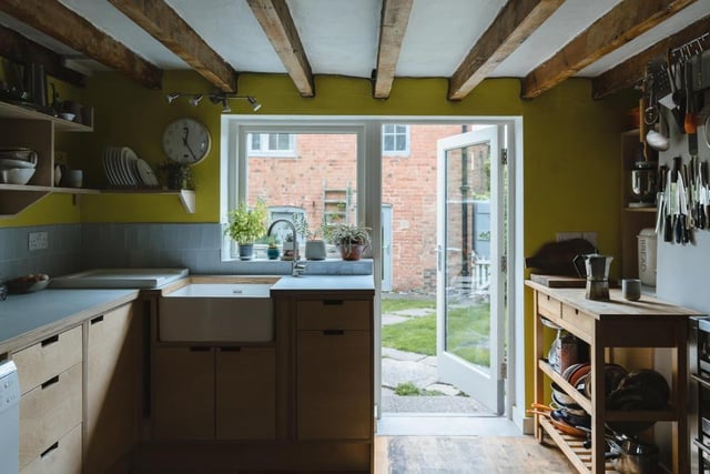 The kitchen is bespoke and constructed of laminated ply. White, hand-cut tiles reflect light and form a splashback, while the walls are painted in chartreuse, adding a vibrant and sunny pop of colour.