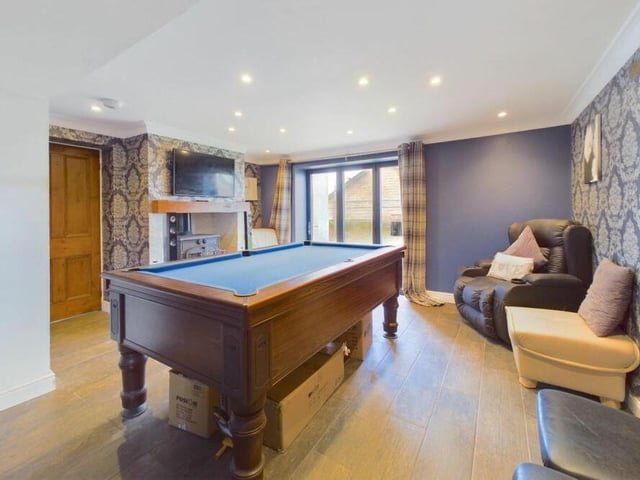 This versatile space can be used for various things, including as a games room. Large doors lead outside to the garden.