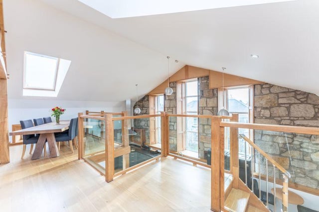 The stairs from the kitchen to the upper level have a feature balustrade made from hardwood and embedded glass.