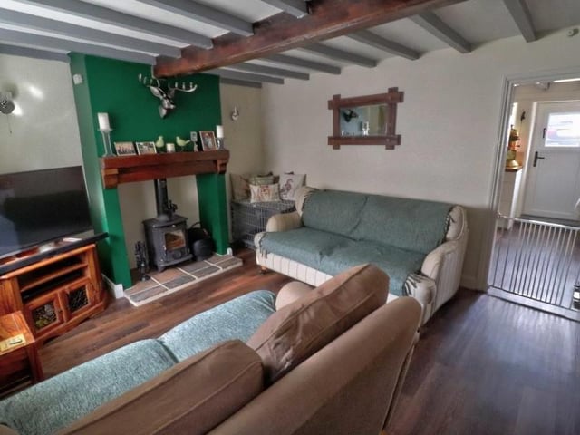 Next door to the dining kitchen is this cosy lounge, which has recently been refitted with Karndean flooring and a multi-fuel log burner.