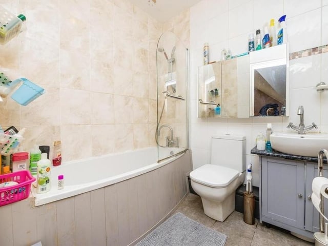 The family bathroom is a busy space, comprising a bath, separate shower, wash hand basin, WC and towel radiator. The floor is tiled.