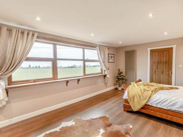 This second shot of the master bedroom at the £550,000 house shows how the window affords spectacular views of open countryside to the north of the property.