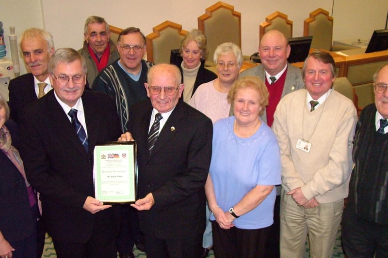 John White (front row, centre) receives a certificate in honour of his 33 years service to Mansfield Twinning Association from chairman of the group Coun Barry Answer while fellow members look on.