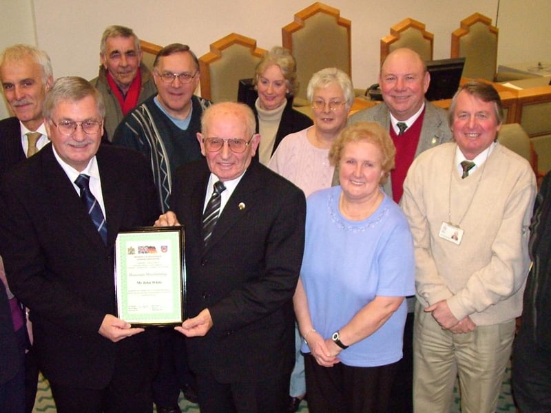 John White (front row, centre) receives a certificate in honour of his 33 years service to Mansfield Twinning Association from chairman of the group Coun Barry Answer while fellow members look on.