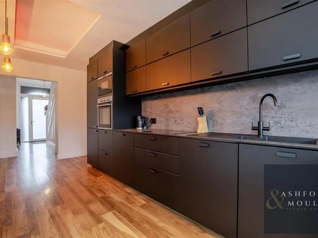 The sleek and modern kitchen features a range of integrated appliances.