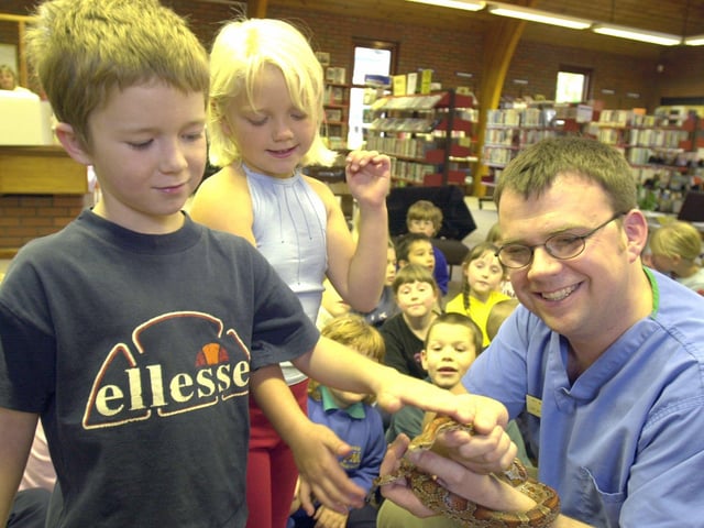 Demi Oxley and Kyle Thompson of Mintini Primary school pictured with Springfield Vet William Taylor and a snake at the Ecclesfield Library in 2001