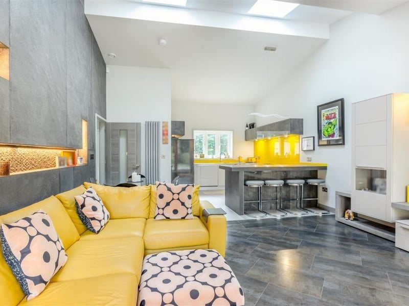 This photo shows how the living area extends seamlessly into the dining kitchen at the Newstead Abbey Park property. You can see a fitted breakfast bar with stools.