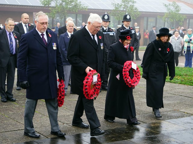 Dignitaries step forward to lay their wreaths