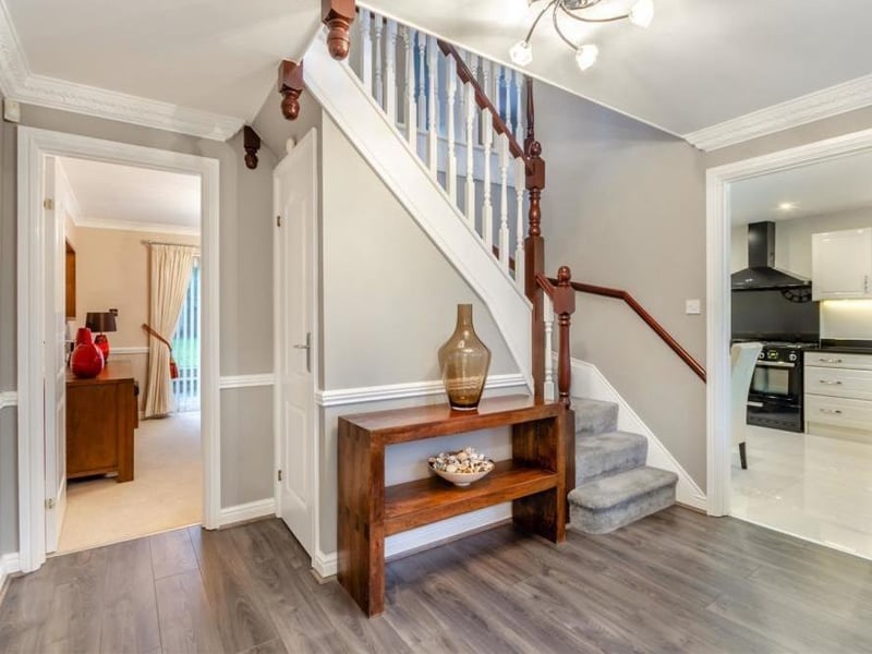 As we prepare to go upstairs, let's take a quick look at the attractive entrance hallway. It comes complete with a wood-effect laminate floor, coving to the ceiling, an under-stairs storage cupboard and stairs leading to a galleried landing.