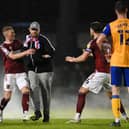 A pitch invader is stopped by Fraser Horsfall of Northampton Town as he runs towards Stags' Oli Hawkins near the end of the semi-final.