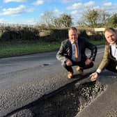 Couns David Martin and Jason Zadrozny next to the huge pot hole on Flatts Lane. Photo: Submitted