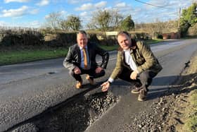 Couns David Martin and Jason Zadrozny next to the huge pot hole on Flatts Lane. Photo: Submitted