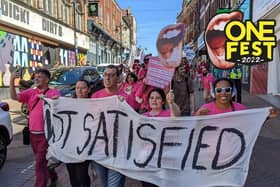The events team holds up a banner saying 'Not Satisfied' as the festival returns for its second year.