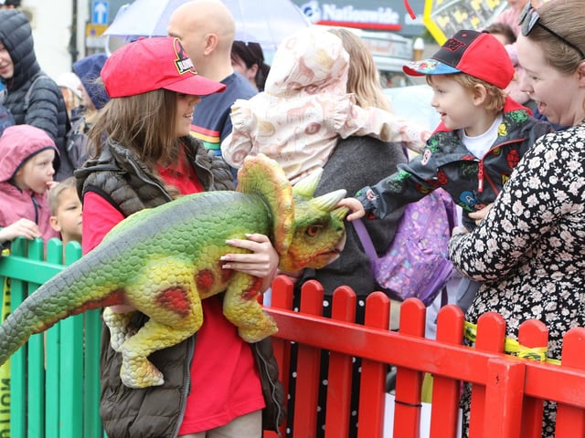 A youngster enjoys a close encounter with a baby triceratops.
