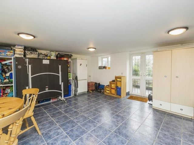 This is the brilliant basement at the £475,000 Dovecote Road bungalow. It has a uPVC French door entrance, two windows, a radiator and tiled flooring. It is so versatile it can be converted into anything you like -- from a games room to a storage spot.