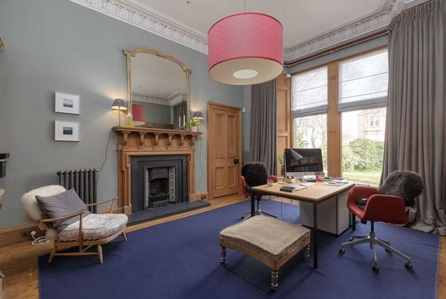 This is one of the reception rooms with a high ceiling and yet another fire place.