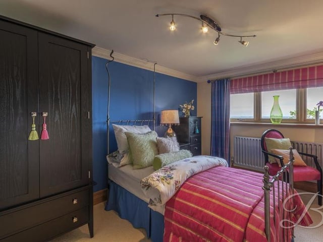 Here is the third bedroom, which is on the downstairs level. It has a carpeted floor, space for wardrobes and a window that overlooks the back of the property. It also has access to en suite facilities.
