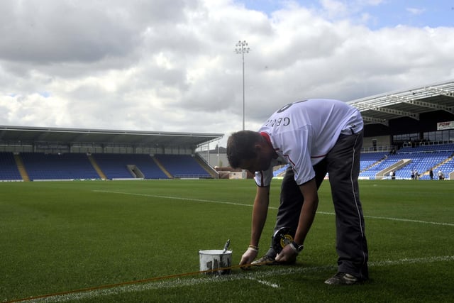 Ground staff put the finishing touches to the pitch.