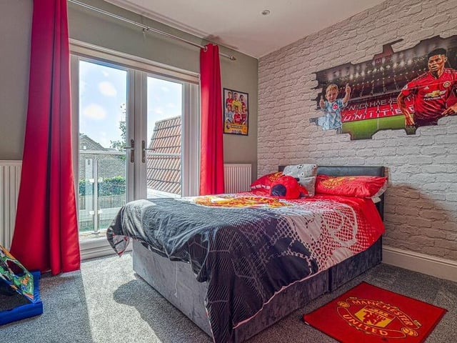 We're on the first floor of the Selston house now to take a look at a couple of bedrooms that have access to a west-facing balcony. This one is currently the retreat of an avid Manchester United fan.