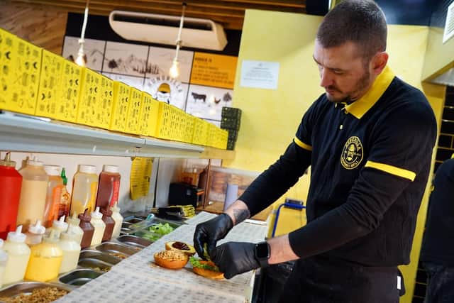Co-owner and chef Hasan Dursun preparing one of the business' popular burgers.
