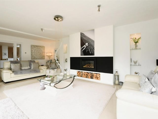 A second look at the sitting room, which features this striking log-effect gas fire. The floor is porcelain tiled.