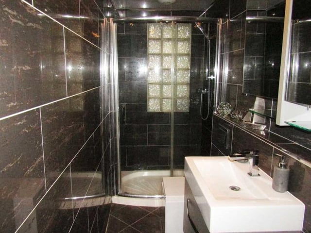 Here is the stylish shower room at the Eastwood bungalow. There is a double shower cubicle, with shower over, a wash hand basin and low-flush WC. The walls and floor are tiled.