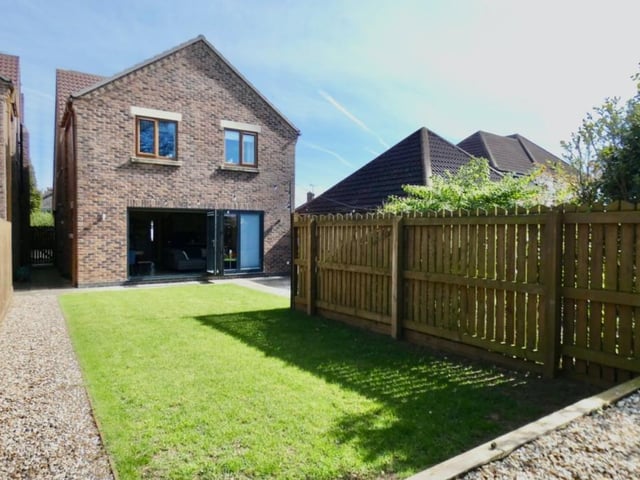 See how the four-bedroom house sits from the back, with its large windows opening out from the open-plan dining/living area next to the kitchen. It's ready for you to to move in.