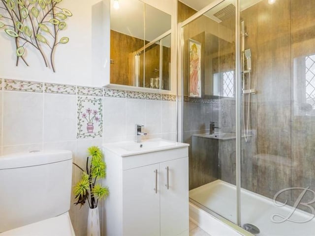 It's hard to fault the stylish en suite facilities attached to the master bedroom. They comprise a walk-in shower cubicle, a low-flush WC, and a hand wash basin with storage. An opaque window faces the back of the bungalow.