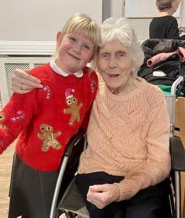 A year 2 pupil from Brinsley Primary School meets one of the residents of Moorlands Care Home in Brinsley.