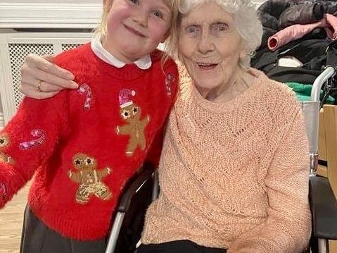 A year 2 pupil from Brinsley Primary School meets one of the residents of Moorlands Care Home in Brinsley.