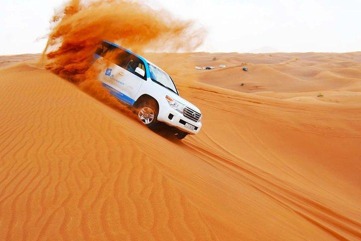 Experience the red dunes of Dubai's Lahbab desert and enjoy activities like sandboarding, 4WD dune bash, camel riding, falcon interaction and more before enjoying a BBQ buffet dinner and live show. By OceanAir Travels.