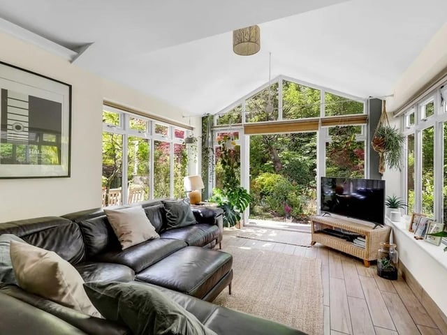 The beautiful snug features a striking gable-style window overlooking the landscaped gardens.