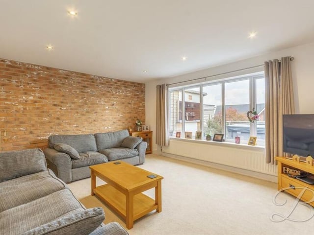 This second living room is ideal for relaxing in front of the telly. The large window overlooks the back of the bungalow, while the floor is carpeted and the ceiling is adorned by downlights.