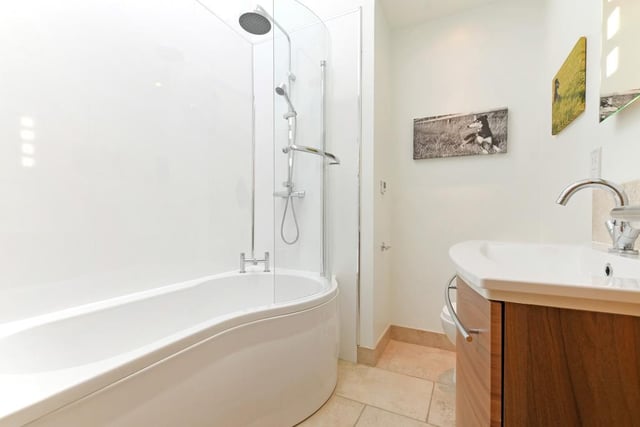 The main bathroom has a Velux roof window, recessed lighting, a 'p' shaped bath and a fitted rain head shower.