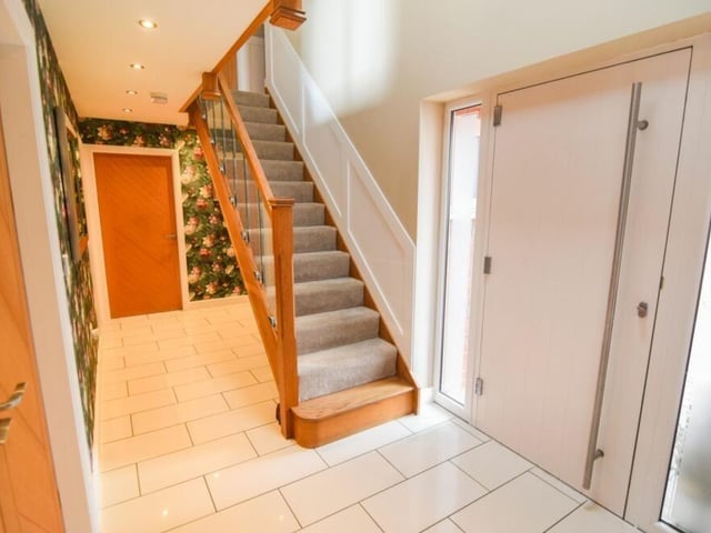 Back into the entrance hall now as we prepare to go upstairs to see the five bedrooms. At the top of the staircase is a landing with a fitted oak banister and glass panels.