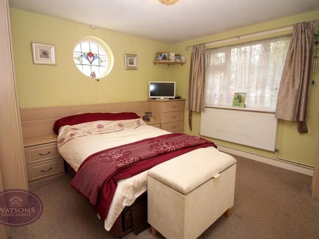 This is the double bedroom that is part of the annexe. It is fitted with a range of furniture and a cupboard housing a combination boiler. It has access to a shower room and a walk-in storage area, while a feature stained glass window is a nice touch.