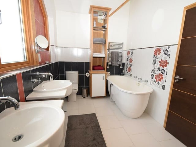 The family bathroom has a bespoke feel, particularly because of its free-standing bath. There is also a walk-in shower area, with rainfall shower, a low-flush WC, twin wash basins, a chrome heated towel-rail and an airing cupboard.