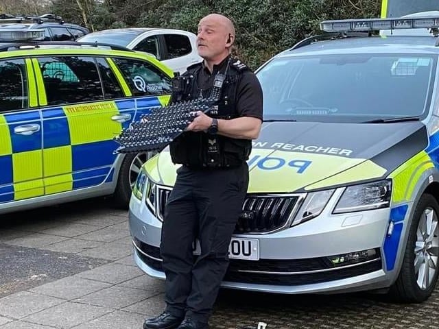 A police officer shows off some of the equipment officers use, such as a stinger to stop cars.