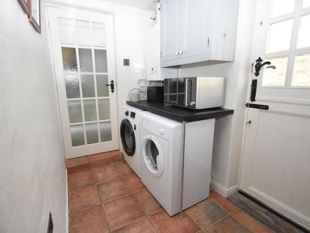 As handy as the pantry is this utility room, which has a worktop counter, plumbing for a washing machine and space for a tumble dryer. The cottage's wall-mounted central heating boiler is also housed here, and there is room for a fridge freezer if necessary. The floor is tiled and a stable-style door leads directly outside to the car port.