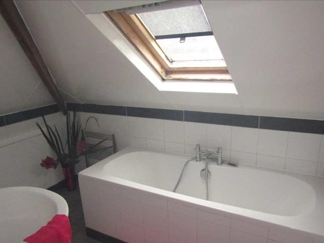 From the entrance hall, there is access to a loft room via ladders. The room boasts this en suite bathroom, with panelled bath, wash hand basin and chrome towel-rail.