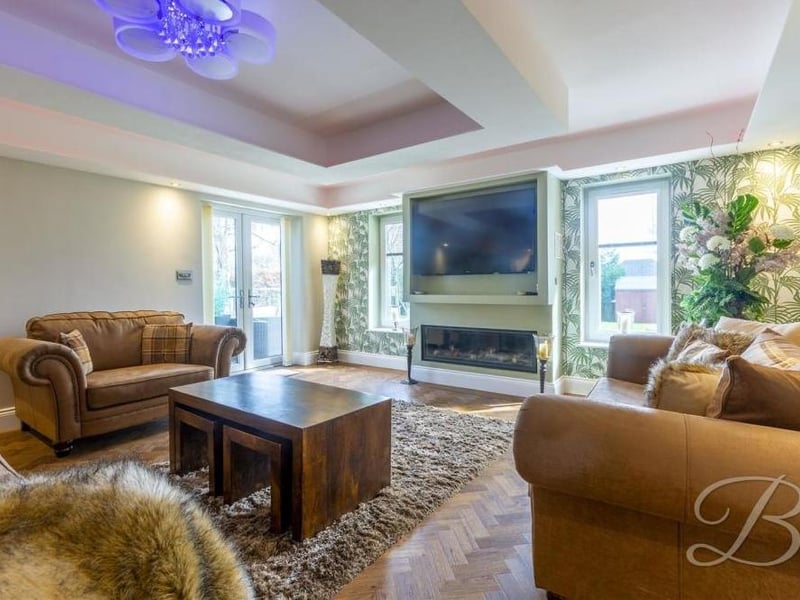 Next stop is this lovely living room, which has two windows overlooking the garden and a set of double doors leading outside.