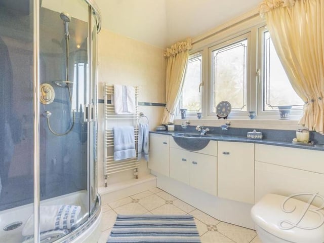 Four of the six upstairs bedrooms at the £1.2 million house boast their own en suite facilities. This elegant example belongs to the biggest bedroom. It comes complete with an enclosed shower, wash hand basin, low-flush WC, vanity unit, heated towel-rail and tiled flooring.