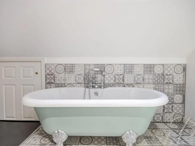 The perfect place to relax and unwind featuring a three-piece bathroom comprising a freestanding claw-foot bath, low-flush WC, and walk-in shower.