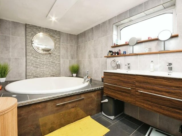 This luxurious en suite bathroom is attached to the master bedroom. A striking circular bath is its highlight, and there is also a separate shower.