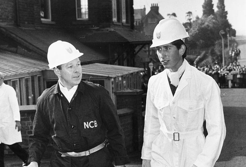 Prince Charles wearing a miners helmet and white overalls as he talks to General Manager W Barrett during a visit to Welbeck Colliery, on July 19th 1968.